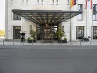 the hotel front entrance is covered in metal and glass, with large windows and an awning