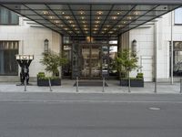 the hotel front entrance is covered in metal and glass, with large windows and an awning