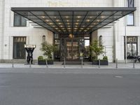 the hotel front entrance is covered in metal and glass, with large windows and an awning