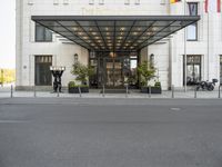 the hotel front entrance is covered in metal and glass, with large windows and an awning