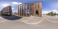 an outdoor street view looking up at a circular building and it's exterior with the building in front