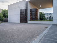 two empty parking spaces with metal tanks on them and one building with a gate open