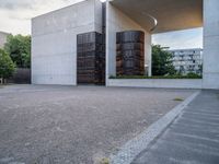 two empty parking spaces with metal tanks on them and one building with a gate open