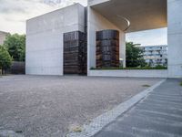 two empty parking spaces with metal tanks on them and one building with a gate open