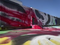 a building with colorful painting on it outside of a shopping center in the day light