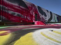 a building with colorful painting on it outside of a shopping center in the day light