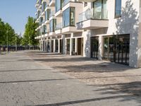 a small child riding a skateboard down a cobblestone sidewalk in front of a tall building