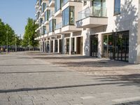 a small child riding a skateboard down a cobblestone sidewalk in front of a tall building