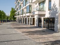 a small child riding a skateboard down a cobblestone sidewalk in front of a tall building