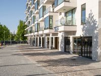 a small child riding a skateboard down a cobblestone sidewalk in front of a tall building