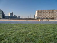 this grass field has been cut short to cover the area in the distance, and it is a grassy area next to an old building