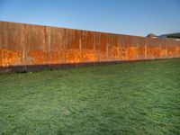 this grass field has been cut short to cover the area in the distance, and it is a grassy area next to an old building