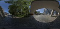 a fisheye lens is showing a walkway through the middle of an open area that leads to the building