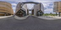 a curved building surrounded by two large arched doors is on a city street with buildings