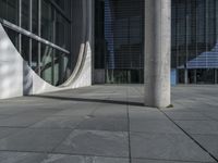 the tall column and concrete pillar of an building on a sunny day, with shadows from large windows