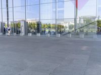 the woman walks through the entrance of a building holding an open umbrella in her hands