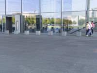 the woman walks through the entrance of a building holding an open umbrella in her hands