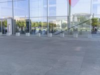 the woman walks through the entrance of a building holding an open umbrella in her hands