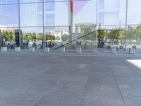 the woman walks through the entrance of a building holding an open umbrella in her hands