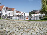 a fire hydrant is shown near a body of water in a city square with boats on the water