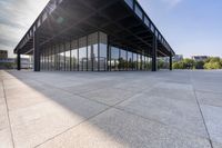 an empty concrete floor is seen with lots of glass walls and steel frame around the structure