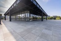 an empty concrete floor is seen with lots of glass walls and steel frame around the structure