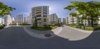 a photo of the view from a street in a very modern city with a wide open sky above and some trees