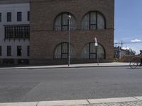 a person riding on a bike in front of a building with large windows on it