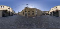 two circular fish eye lens images of an empty street in the city area of a small town