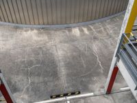 a photo looking down onto a cement floor with stairs leading to the bottom of the wall