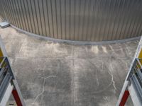 a photo looking down onto a cement floor with stairs leading to the bottom of the wall