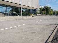 a person skateboarding down an empty sidewalk in front of a building with glass walls