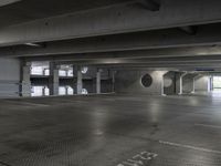 a empty parking garage with light coming through the windows and a floor grid pattern in place to protect from people