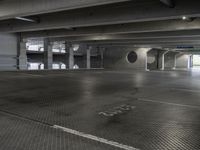 a empty parking garage with light coming through the windows and a floor grid pattern in place to protect from people