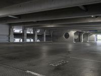 a empty parking garage with light coming through the windows and a floor grid pattern in place to protect from people