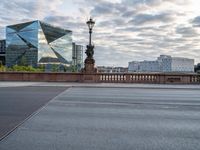 a person that is sitting on a motorcycle in front of a bridge with some buildings in the background