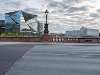 a person that is sitting on a motorcycle in front of a bridge with some buildings in the background