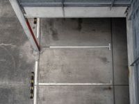 parking spaces with yellow cautions and red doors on a sidewalk and floor in an empty building