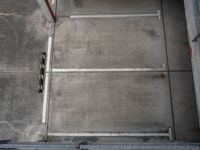 parking spaces with yellow cautions and red doors on a sidewalk and floor in an empty building