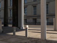 a couple of pillars standing next to each other in front of a building with windows