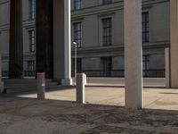 a couple of pillars standing next to each other in front of a building with windows