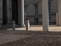 a couple of pillars standing next to each other in front of a building with windows