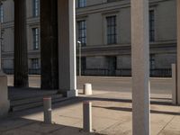 a couple of pillars standing next to each other in front of a building with windows