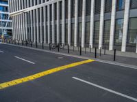 the empty street with bicycles parked in front of the buildings has a sign that says the library on it