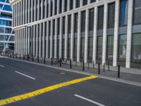 the empty street with bicycles parked in front of the buildings has a sign that says the library on it