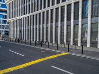 the empty street with bicycles parked in front of the buildings has a sign that says the library on it