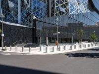 a large building with a glass and steel structure on top of it by a street