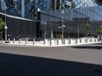 a large building with a glass and steel structure on top of it by a street