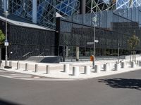 a large building with a glass and steel structure on top of it by a street