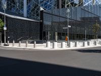 a large building with a glass and steel structure on top of it by a street